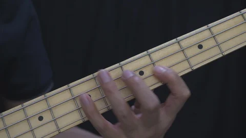A man in black is practicing scale and chord on an electric guitar bass at home. Video stock 127609774