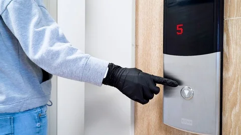 A man in black protective gloves presses the Elevator button during Stock Footage 128126325