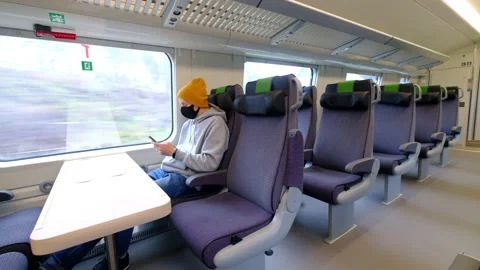 A man in a black protective mask sits alone in the train Stock Footage 142429628