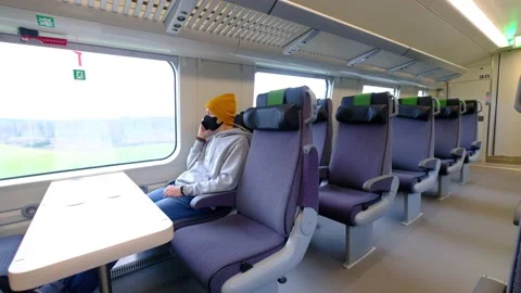 A man in a black protective mask sits alone in the train Stock Footage 142429632
