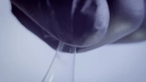 A man in black rubber gloves opens an ampoule with a medicine, light background Stock Footage 160764972