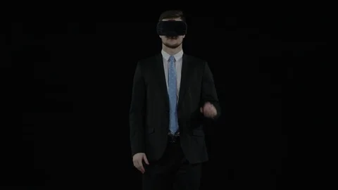 Man on a black screen wears aughmented reality glasses and works in virtual Stock Footage 77677800