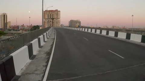 A man in a black shape running along an empty road Stock Footage 132349521