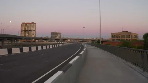 A man in a black shape running along an empty road Stock Footage 132349537