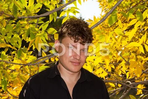 Man in a black shirt on the background of autumn Stock Photos