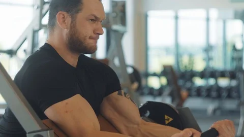 A man in a black shirt doing exercise for hands at the simulator Stock Footage 126979582