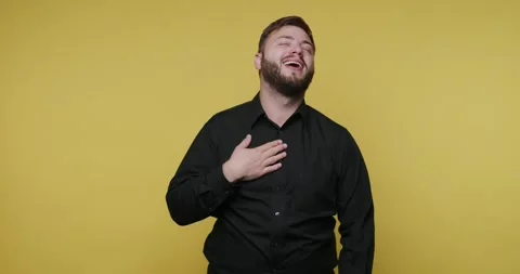 Man in black shirt performs a funny act with a bright yellow background dur.. Vídeo Stock 326789403