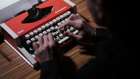 A man in a black shirt types text on a printing press. Medium shot. Red Stock Footage 198797187