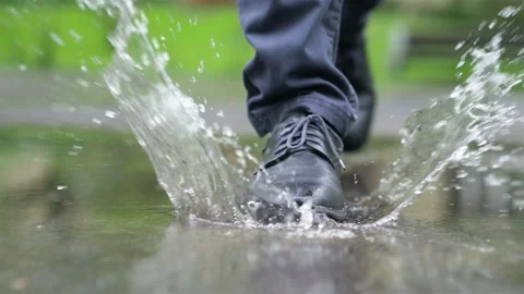 Man in black shoes stepping into the puddle in slow motion 180fps Stock Footage 93432353