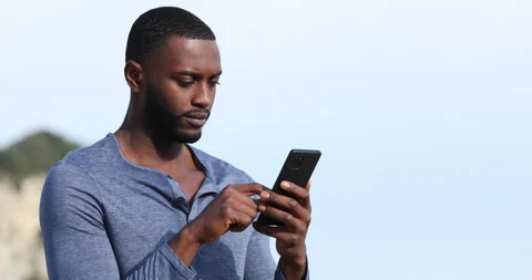 Man with black skin using smart phone outdoors Stock Footage 168703392