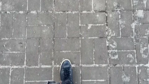 Man in black sneakers walks down the street on a Winter day. Pov. Slow Motion Stock Footage 169865175