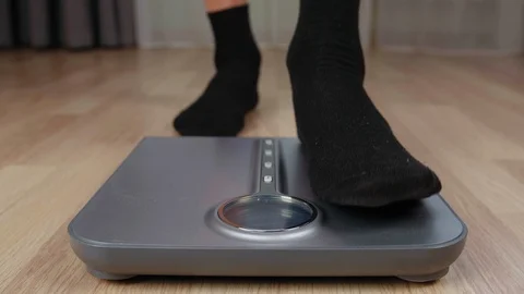 Man in black socks checking weight on electronic scale with display Stock Footage 96329971