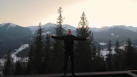Man in black standing on mountain viewpoint in winter Carpathians, sunset sky Stock Footage 308496315