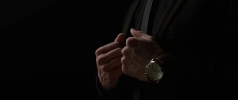 A man in a black suit straightens his jacket. Stock Footage