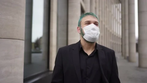 Man in black suit takes off his mask and breathes 스톡 동영상 132640341