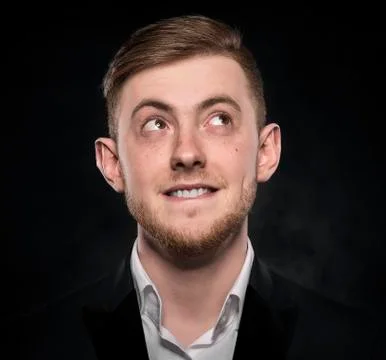 Man in black suit thinking or dreaming. Stock Photos