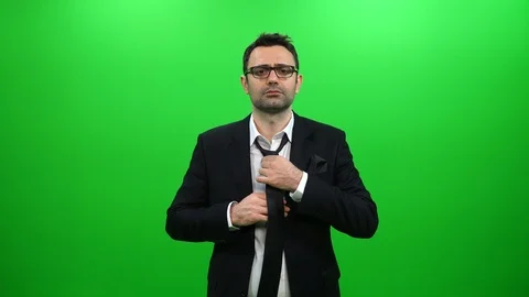 Man In Black Suit Tying A Tie On A Green Background Stock Footage 88651866