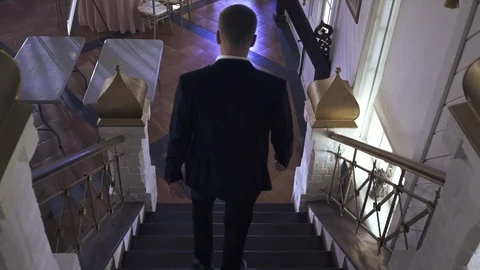 Man in black suite is walking down the stairs Stock Footage 101570902