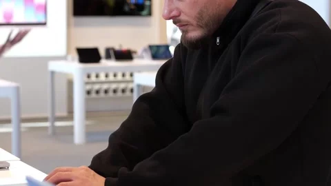 Man in Black Sweater Testing Laptops in Modern Electronics Store Stock Footage 331384003