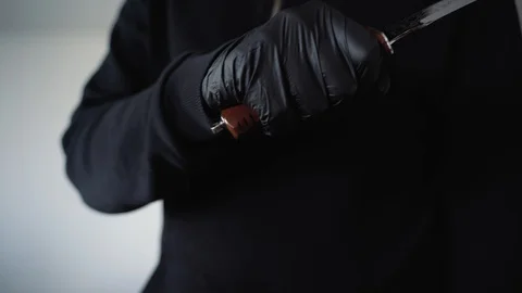 A man in black waves a knife threateningly in front of the camera Vidéo 129556194