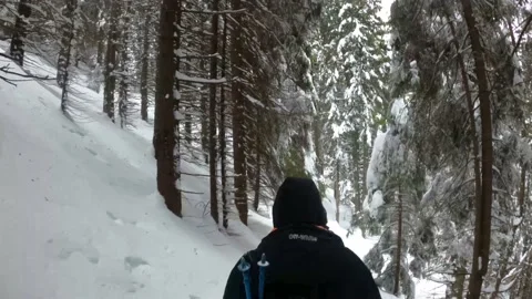 Man In A Black Winter Jacket And A Backpack Walking On Snow Covered Mountain Stock Footage 150963633