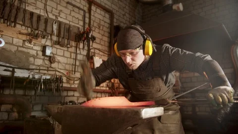 A man blacksmith forging a knife in workshop Stock Footage 125346891