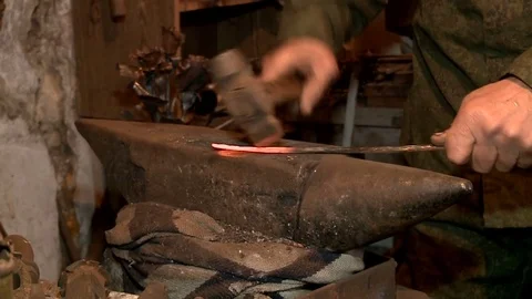 Man blacksmith has an effort on glowing hot metal and sparks fly Video stock 75160072