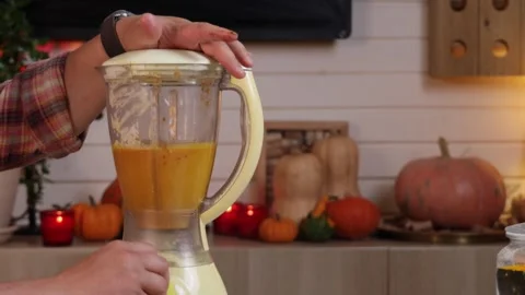 A man blends all the ingredients in a blender to make pumpkin pie Stock Footage 286104508
