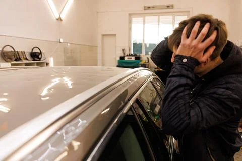 Man blocking his ears in front of a vehicle, showing a disapproving gesture Stock Photos