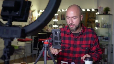 A man blogger makes himself a make-up. records video on the phone Stock Footage 128917363