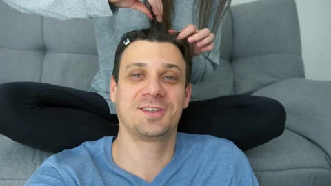 Man blogger speaking at camera while woman is doing his hair french braids. Stock-Footage 168098158