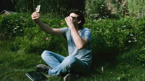 Man blogger talks on video chat, shooting herself on a mobile phone, selfie Stock Footage 102450660