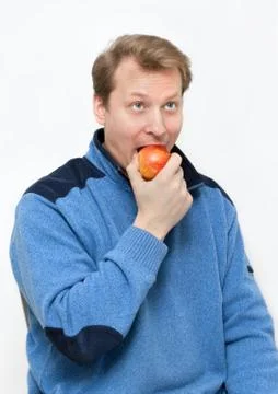 Man blond eats apple Stock Photos