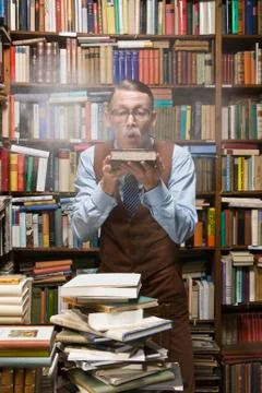 A man blowing dust off an old book Stock Photos