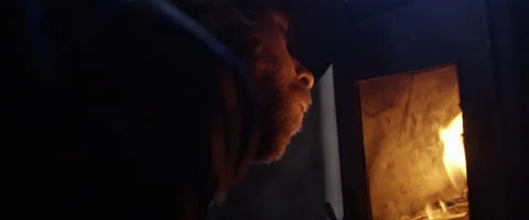 Man blowing flames to light logs in fireplace Vidéo 68496172