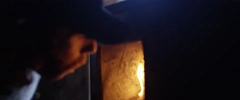 Man blowing flames to light logs in fireplace Stock Footage 68496200