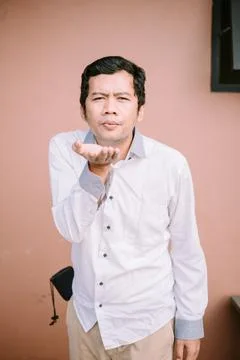 A man blowing something gently, capturing a moment of focused intent Stock Photos