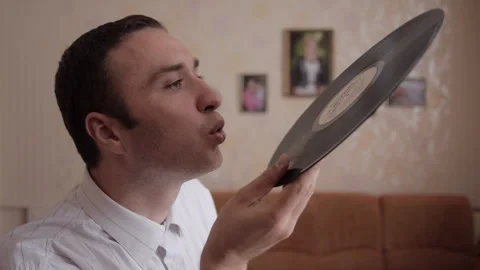 Man Blows Dust Off Vinyl Record 스톡 동영상 328609544
