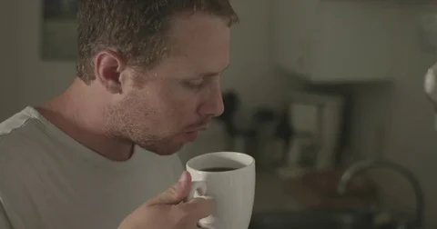 Man blows on hot cup of tea Stock Footage 78038311