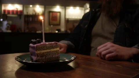 A man blows out a candle in a cake Stock Footage 223880859