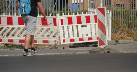 Man With Blue Backpack Walks In Front Of Red-White Roadblock Grey Audi Coupe Go Stock Footage 53835309