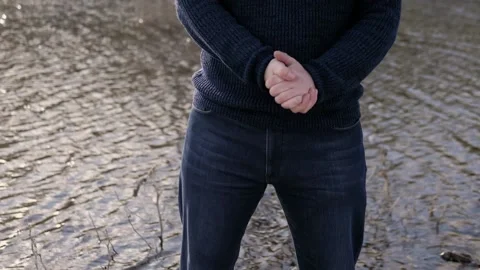 Man in blue clothes makes welcome gestures with his hands.In background is river Stock Footage 130726189