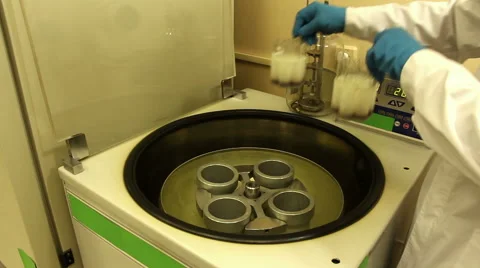 Man in blue gloves loads and starts centrifuge Stock Footage 58399474