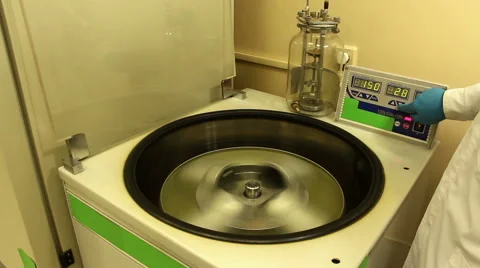 Man in blue gloves stops and unloads centrifuge Stock Footage 58399627