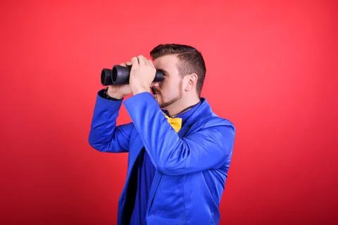 Man in blue jacket looking through binoculars Stock Photos