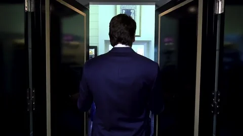 A man in a blue jacket opens black doors and enters a store with men's clothing Stock Footage 260260943