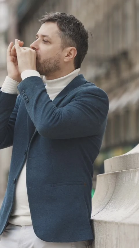 A man in a blue jacket plays the harmonica on the street during the rain Vidéo 328343251