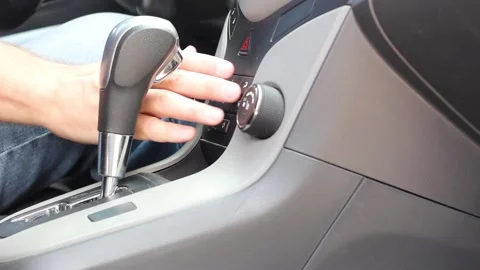 A man in blue jeans presses buttons on the dashboard in a car close-up Stock Footage 136509351