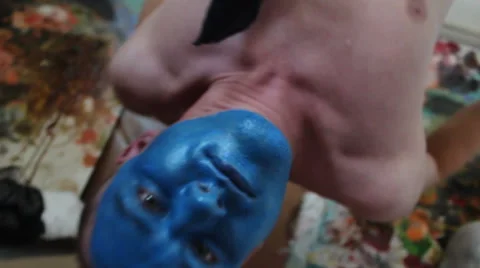 Man with blue painted face hanging upside down Stock Footage 48868271