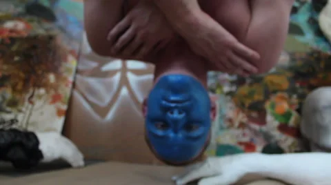 Man with blue painted face hanging upside down Stock Footage 48870498